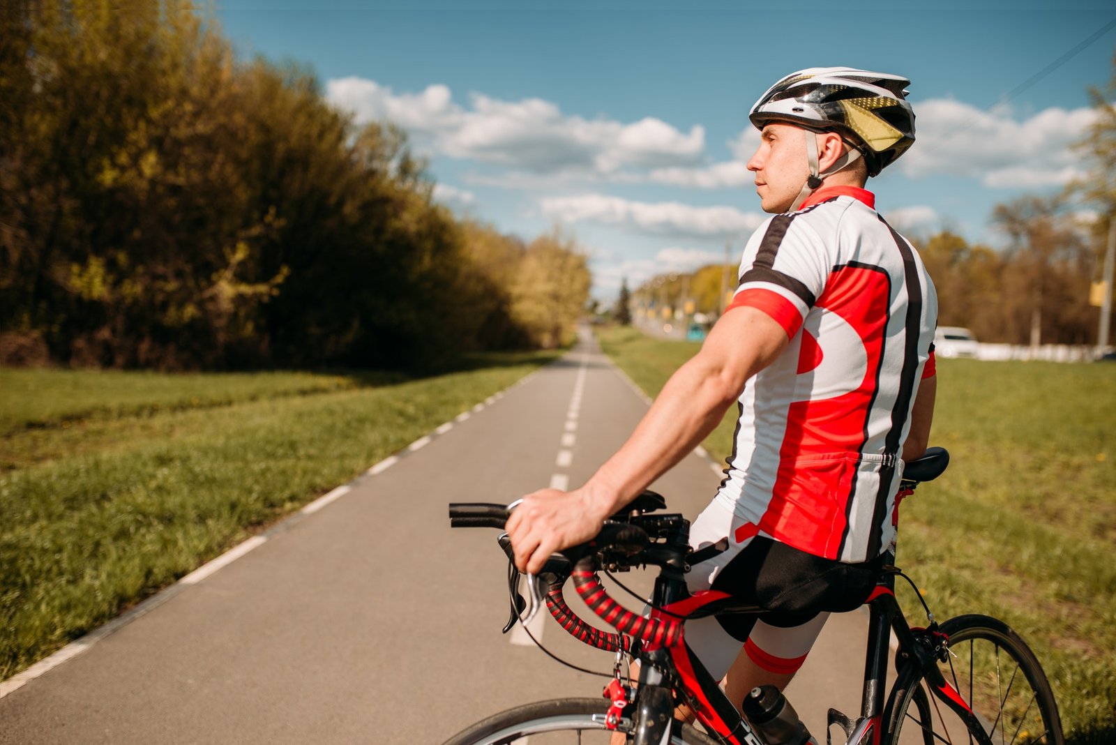 Cyclist in sportswear, cycling on asphalt road